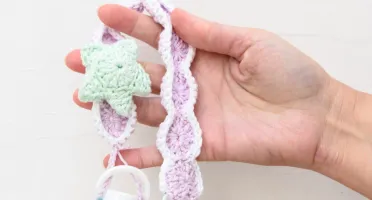 Prendedor de chupeta lilás com estrela do mar em crochê