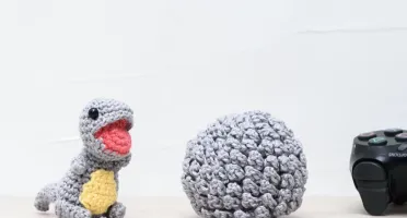 Ovo com filhote de dinossauro cinza em amigurumi