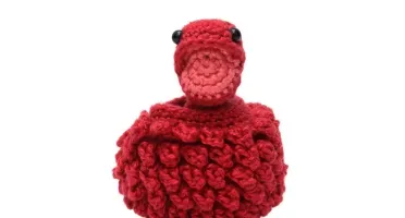 Ovo com filhote de dinossauro vermelho em amigurumi