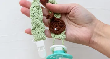 Prendedor de Chupeta Verde Trançado com Detalhe Amigurumi