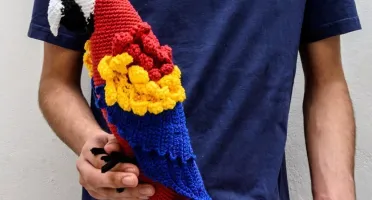 Arara vermelha e amarela em amigurumi