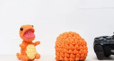 Ovo com filhote de dinossauro laranja em amigurumi