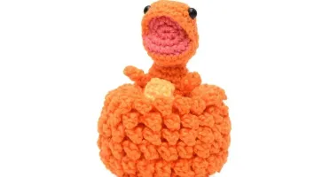 Ovo com filhote de dinossauro laranja em amigurumi