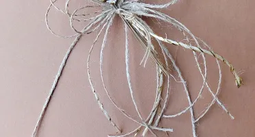 Laço de fios de juta com buquezinho de flores secas