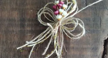 Laço de fios de juta com buquezinho de flores secas