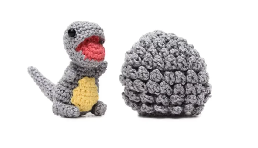Ovo com filhote de dinossauro cinza em amigurumi