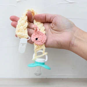 Prendedor de Chupeta Amarelo Trançado com Detalhe Amigurumi - Artesanato e Personalizados