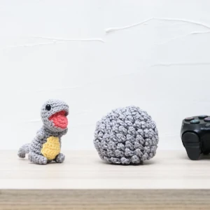 Ovo com filhote de dinossauro cinza em amigurumi - Artesanato e Personalizados