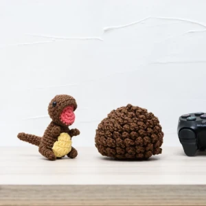 Ovo com filhote de dinossauro marrom em amigurumi - Artesanato e Personalizados